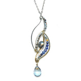 Sterling silver and brass wing shapes combined to make one pendant featuring moonstone, blue crystal, labradorite, kyanite, and lapis gemstones with a blue quartz hanging drop to complete the necklace