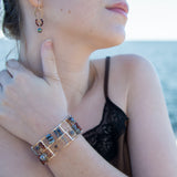 Bronze and sterling silver wide bracelet with labradorite, hessonite garnet, iolite, pyrite, and blue opal gemstones, with  twisted brass accents