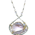raw amethyst nugget is held in brass and gold filled wire with faceted amethyst and labradorite gemstones accents all inside a sterling silver pendant pendant