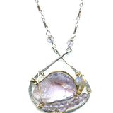 raw amethyst nugget is held in brass and gold filled wire with faceted amethyst and labradorite gemstones accents all inside a sterling silver pendant pendant