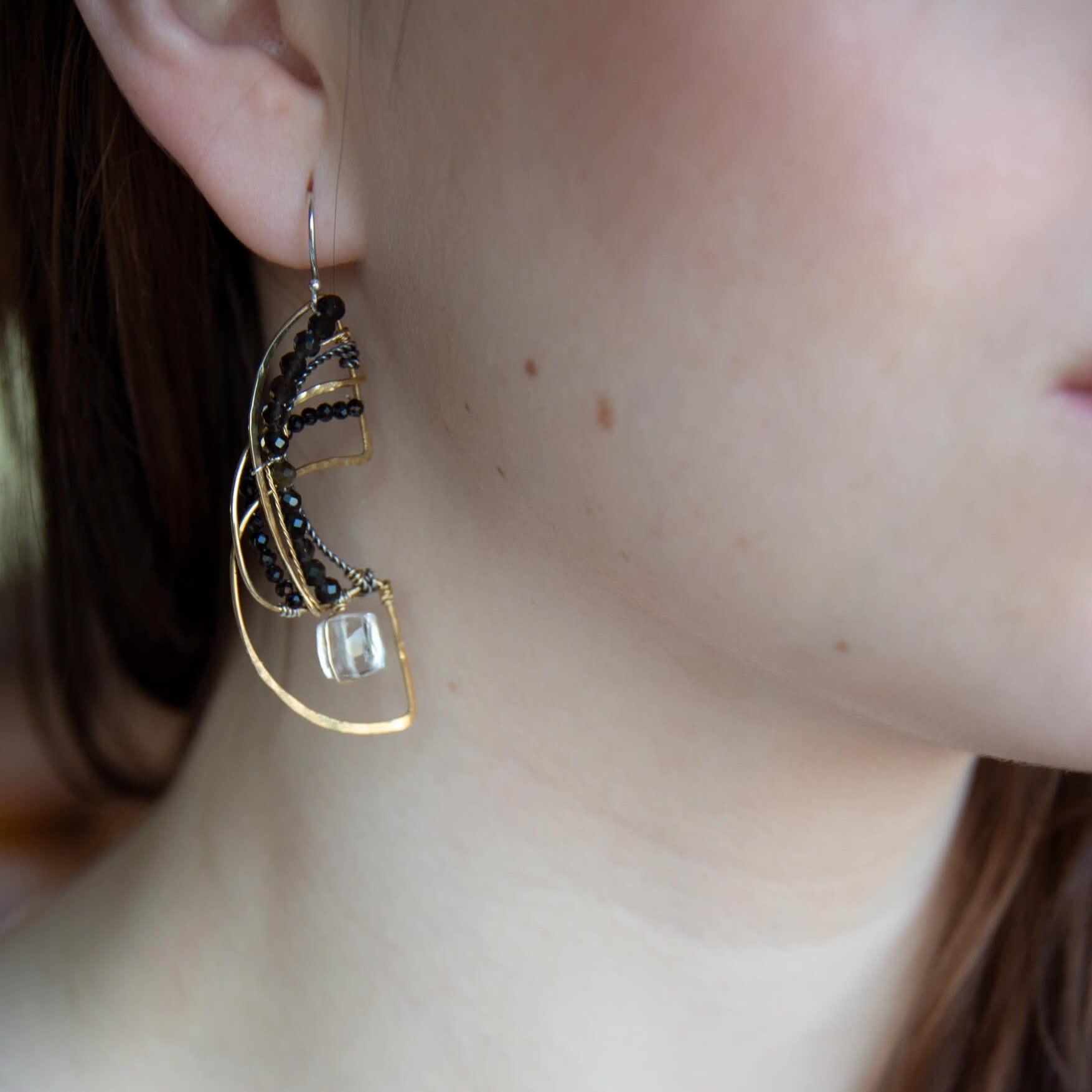 Brass hammered earrings line with dark olive cat's eye, black spinel, and quartz cube gemstones
