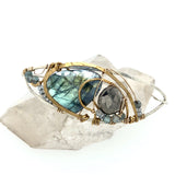 Flashy labradorite, pyrite, and apatite gemstones share space within a sterling silver and brass cuff bracelet with gold filled wire