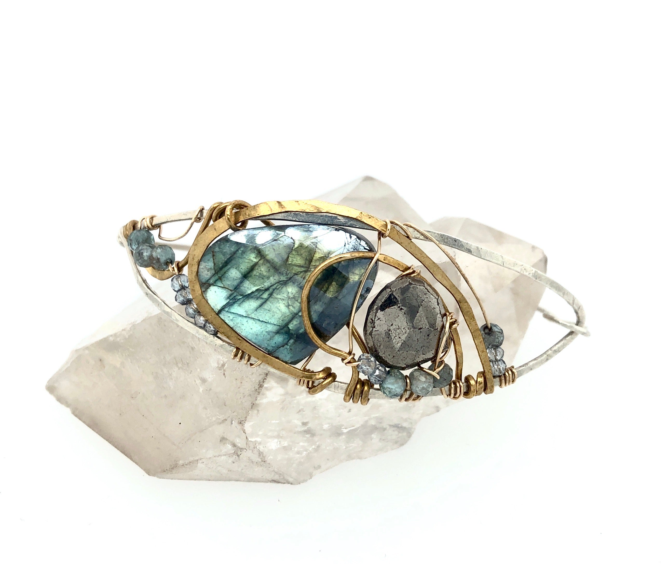 Flashy labradorite, pyrite, and apatite gemstones share space within a sterling silver and brass cuff bracelet with gold filled wire