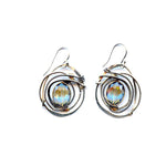 A pair of sterling silver earrings featuring a hammered design with a central blue crystal, edged with oxidized sterling silver twist wire