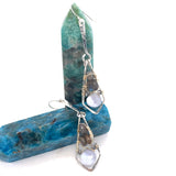 A pair of sterling silver arrow earrings featuring blue lace agate drops and flashy labradorite gemstones, set in gold-filled.