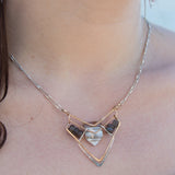 A brass and sterling silver pendant necklace featuring a blue lace agate point and faceted flashy labradorite gemstones with a doubled sterling silver sparkly chain